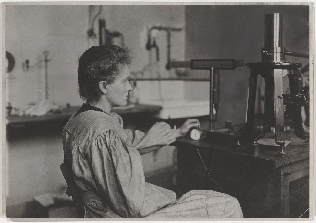 [[Foto001.jpg Año 1904. Cronómetro en mano, Marie Curie en plena medición de la radioactividad en su laboratorio parisino. The Nobel Prize. Women who changed science: Marie Curie https://www.nobelprize.org/womenwhochangedscience/stories/marie-curie]]